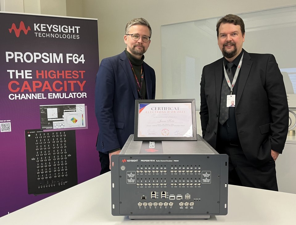 Keysight Finlandin Go-to-market manageri Jani Tolonen ja Business Oulun ICT-alan Key Account Director Jussi Leponiemi tarkastelemassa PROPSIM FS16 -radiokanavaemulaattorin voittamaa Kultainen Elektroni -innovaatiopalkintoa.